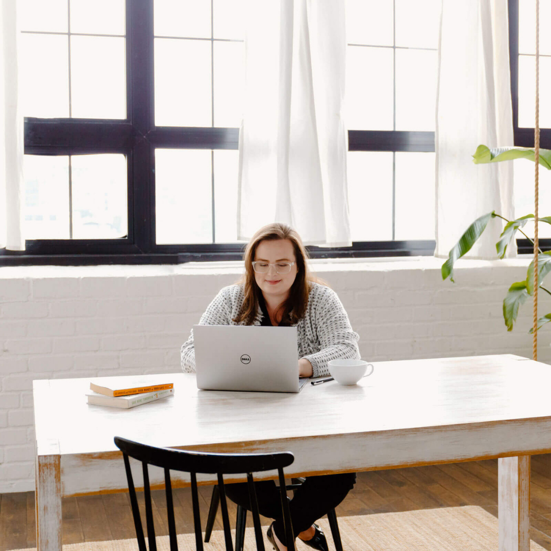 Jenna VanLeeuwen sitting at a desk working on a laptop
