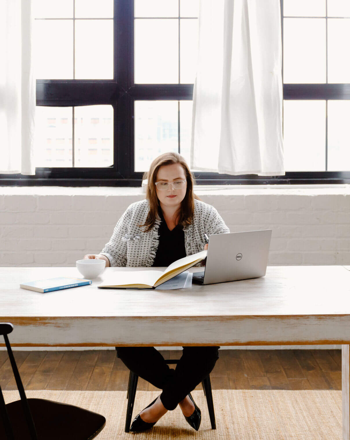 Jenna working at a computer in front of a window
